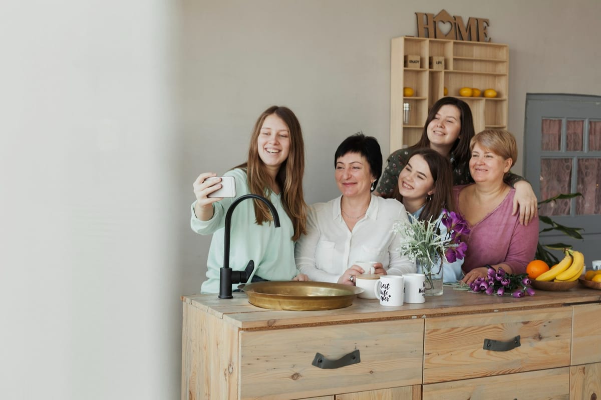 A group of five women taking a groufie by a kitchen countertop